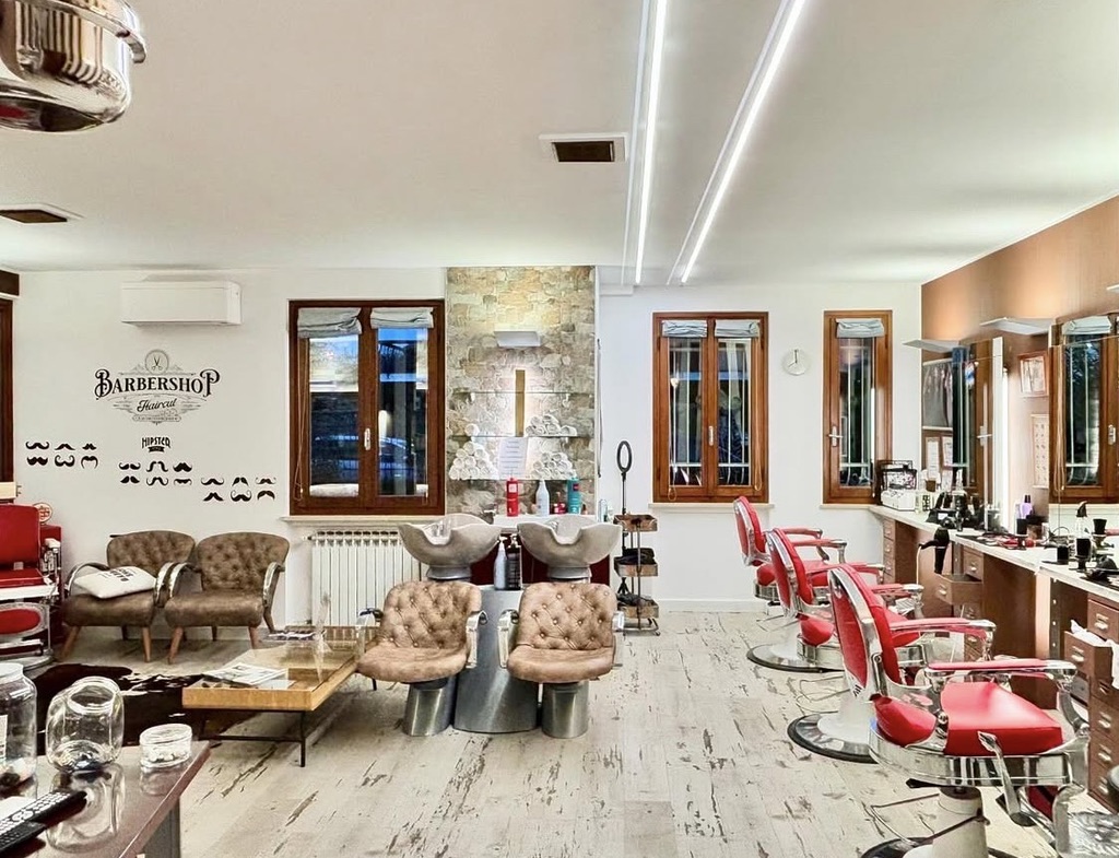 Sala d'attesa del Barbershop con poltrone vintage e dettagli in pietra